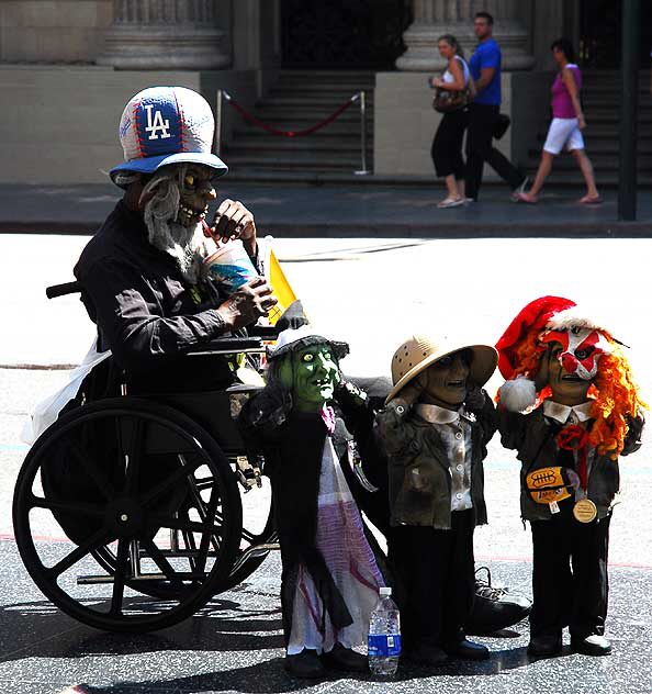 Man in wheelchair with dolls, Hollywood Boulevard in front of the Kodak Theater, Monday, September 15, 2008