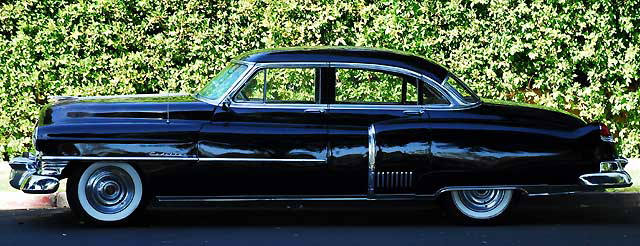 1953 Cadillac sedan, in formal black, parked in the shade not far from Beverly Hills City Hall