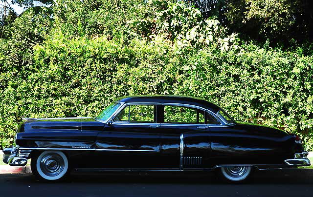 1953 Cadillac sedan, in formal black, parked in the shade not far from Beverly Hills City Hall