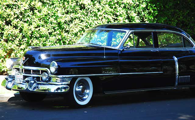 1953 Cadillac sedan, in formal black, parked in the shade not far from Beverly Hills City Hall