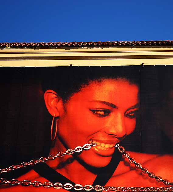 Woman chewing chain, building warp, Santa Monica Boulevard