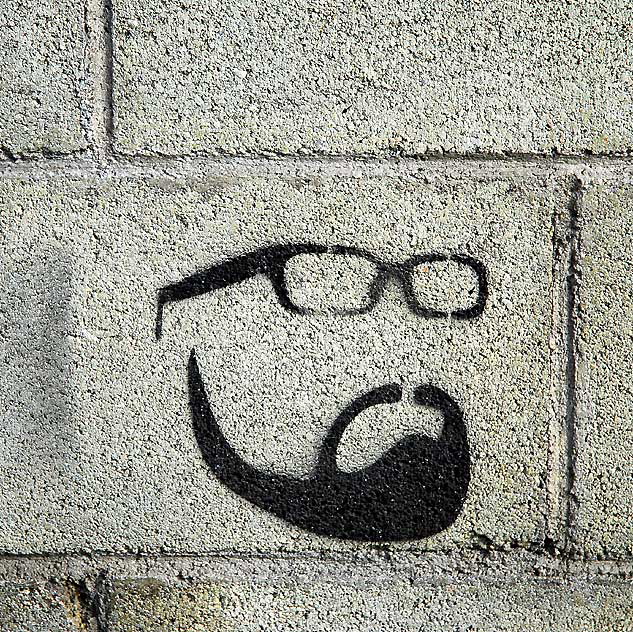 Stenciled face on concrete block wall 