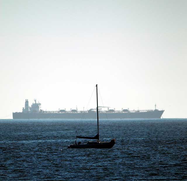 Sailboat at anchor and oil tanker offloading Alaskan crude for the Chevron refinery in El Segundo