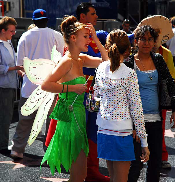 Tinkerbelle impersonator with tourists and other impersonators, on Hollywood Boulevard