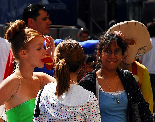 Tinkerbelle impersonator with tourists and other impersonators, on Hollywood Boulevard