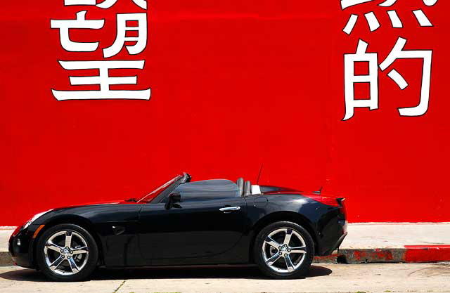 Black Solstice convertible, red wall, Geisha House, Hollywood Boulevard 