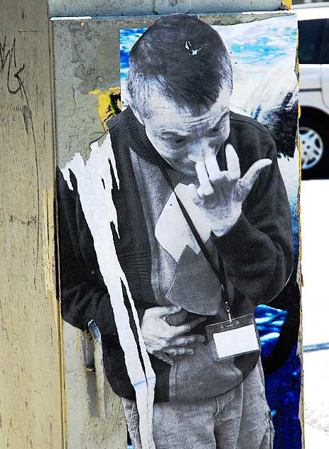 Poster, man picking his nose, utility box on La Brea