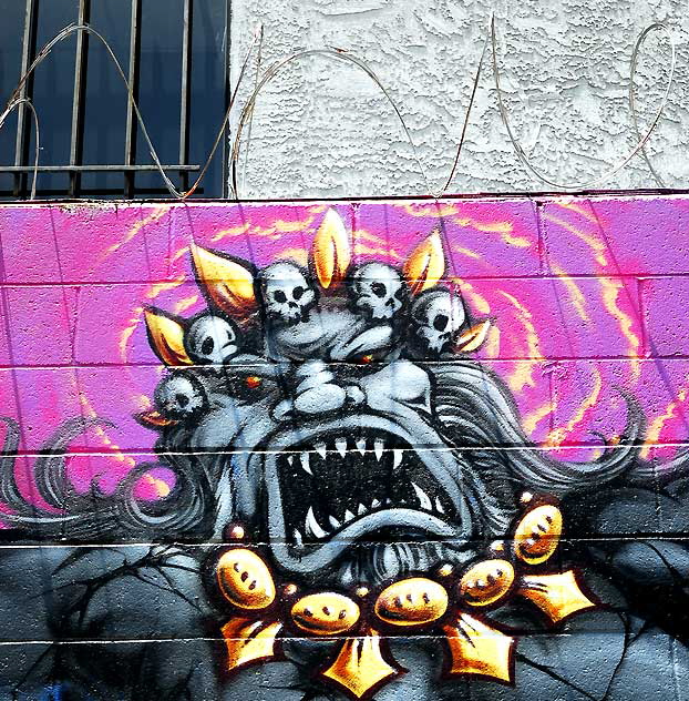 Monster on pink wall with razor wire, Melrose Avenue alley