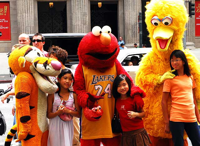 Asian kids posing with cartoon impersonators, Hollywood Boulevard