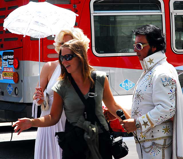 Elvis Presley and Marilyn Monroe impersonators with tourist in front of the Kodak Theater