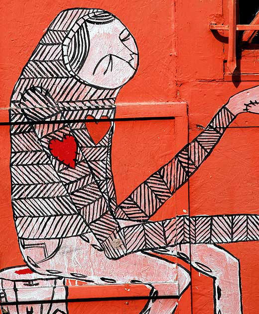 Figure with heart on sleeve - orange plywood wall at Heliotrope and Melrose, just south of LA City College