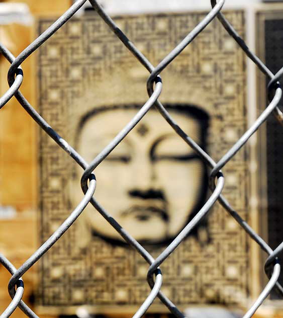 Buddha behind chain link fence, West Sunset Boulevard, Sunset Junction 