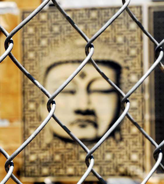 Buddha behind chain link fence, West Sunset Boulevard, Sunset Junction 