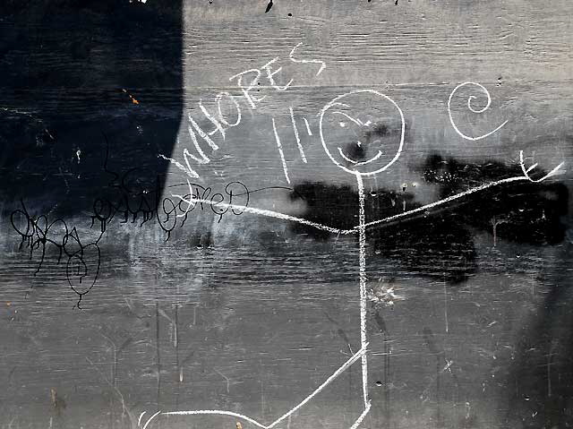 "Whores" - stick figure on wooden wall near Hollywood and Vine