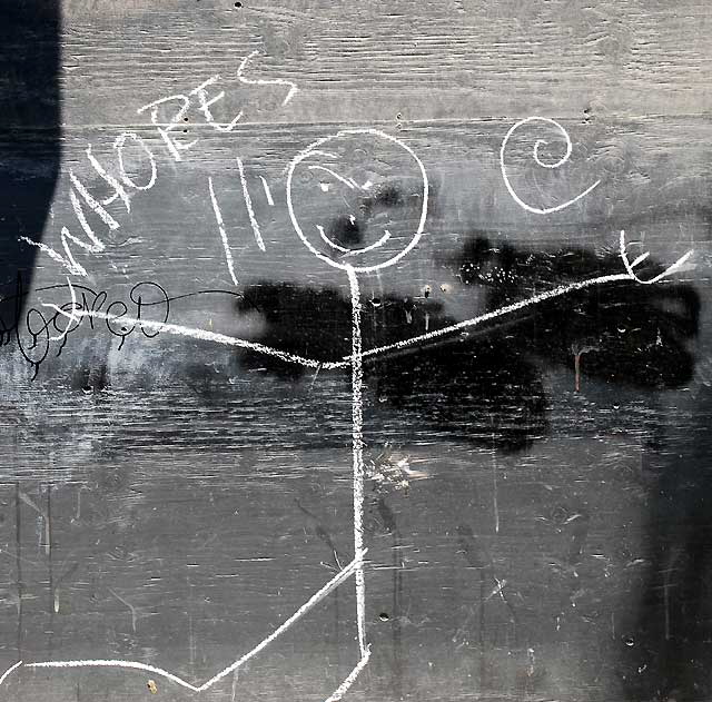 "Whores" - stick figure on wooden wall near Hollywood and Vine
