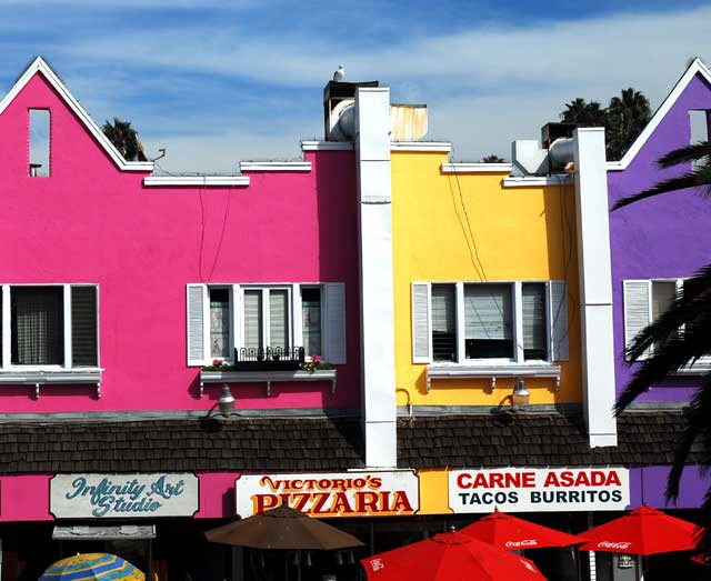 At the base of the Santa Monica Pier, under the bridge, a row of color on Ocean Front 