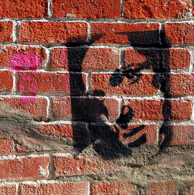 Face Stencil on Brick Wall