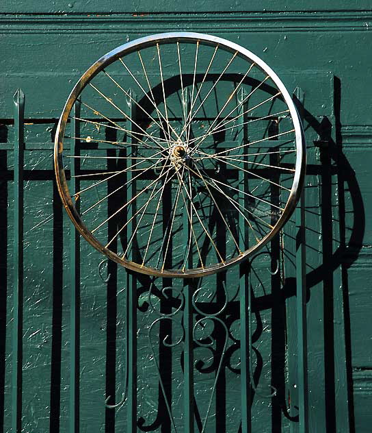 Bicycle wheel on wall of repair shop near Heliotrope and Melrose