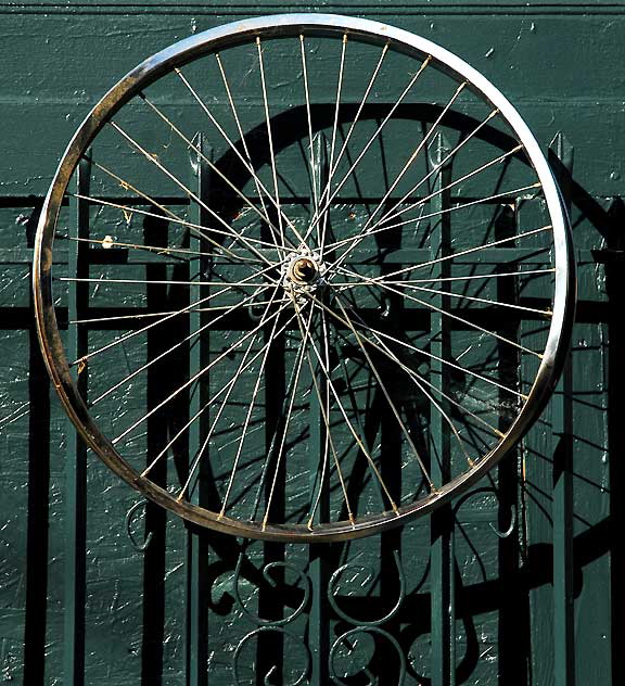 Bicycle wheel on wall of repair shop near Heliotrope and Melrose