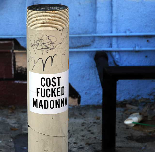 Sticker on post - "Cost... Madonna"