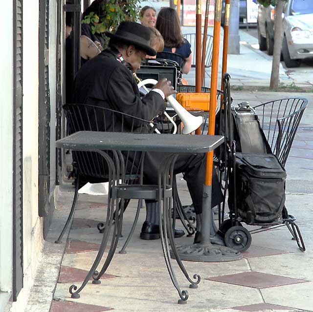 Man playing a white flugelhorn, Hollywood sidewalk