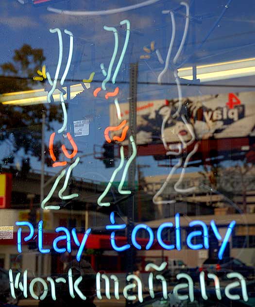 Neon escapist messages in a liquor store window on Pico, near the freeway