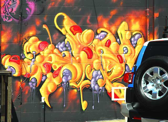 Orange graffiti wall with blue SUV, Melrose Avenue