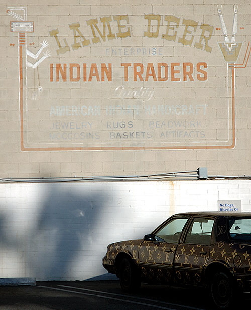 In the bank parking lot, Santa Monica Boulevard - Historic Route 66 - at Crescent Heights - a long abandoned business and an old beat-up Oldsmobile covered with the YSL logo