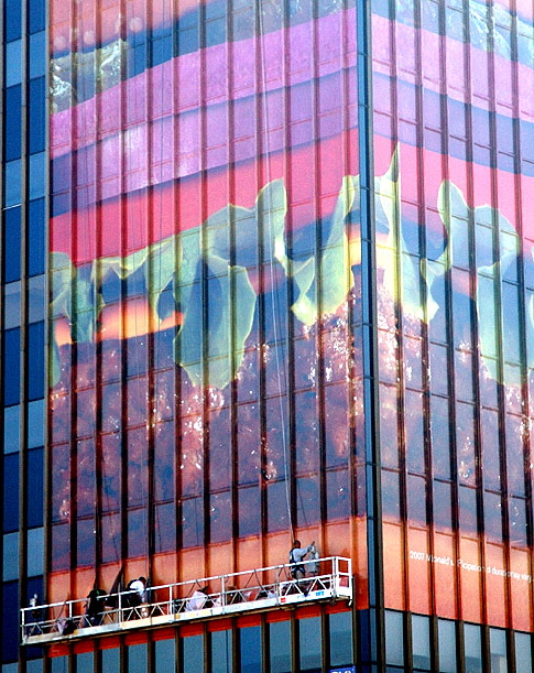 Guys on scaffolds applying new advertising to the TV Guide building, Hollywood Boulevard