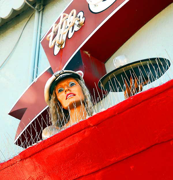 Mermaid cocktail waitress in red boat above a restaurant, Main Street, Ocean Park