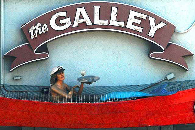 Mermaid cocktail waitress in red boat above a restaurant, Main Street, Ocean Park