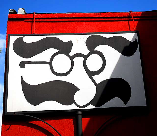 Eyeglasses and mustache on red wall, pawnshop, Santa Monica Boulevard at Genesee, West Hollywood