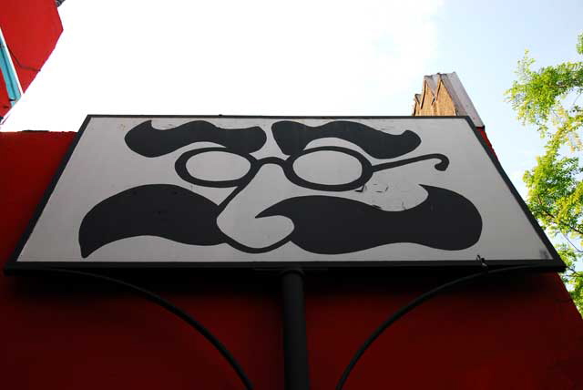 Eyeglasses and mustache on red wall, pawnshop, Santa Monica Boulevard at Genesee, West Hollywood