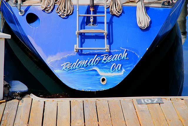 The boat slips at the Redondo Beach Pier - blue stern with painted wave