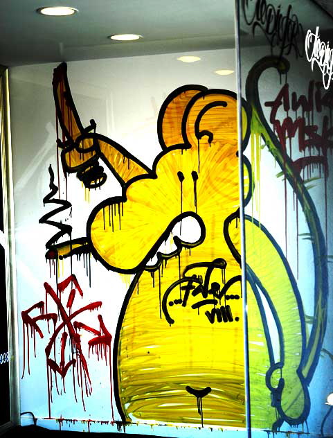 Yellow rat with bloody knife and cigarette - graphic in the window of a Fairfax District art gallery