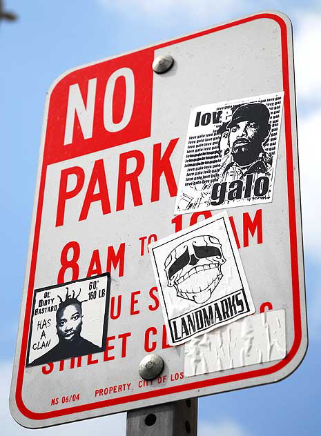 No Parking sign with stickers, beside mural on the northwest corner of Gower and Warning, across the street from the massive Paramount Studios