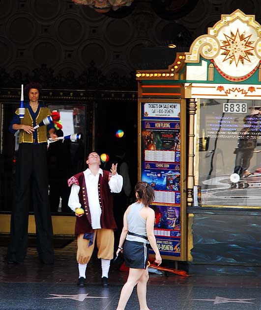 Man on stilts and short man, jugglers at El Capitan Theater, Hollywood Boulevard