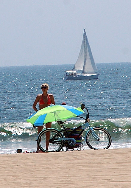Blond on the sand with bicycle, sailboats in background, Venice Beach