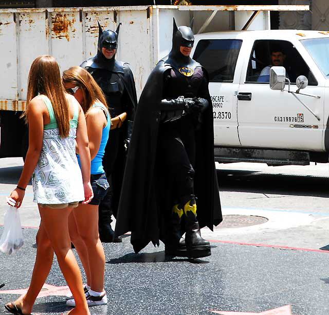 On Hollywood Boulevard, two Batman impersonators checking out the young babes, while a guy in a garbage truck looks on -