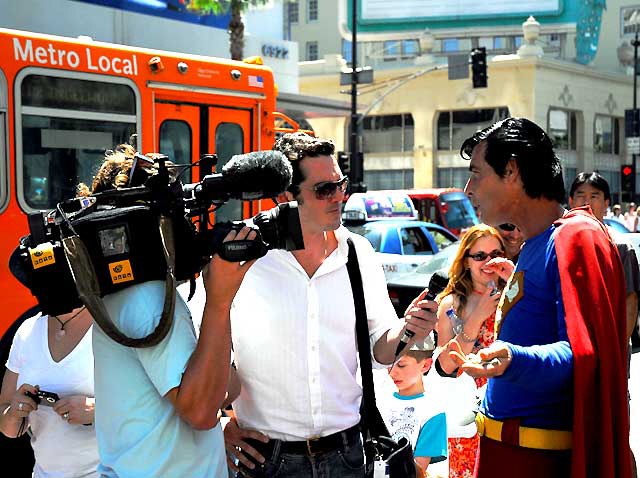 Superman impersonator being interviewed in front of Grauman's Chinese Theater, Hollywood Boulevard
