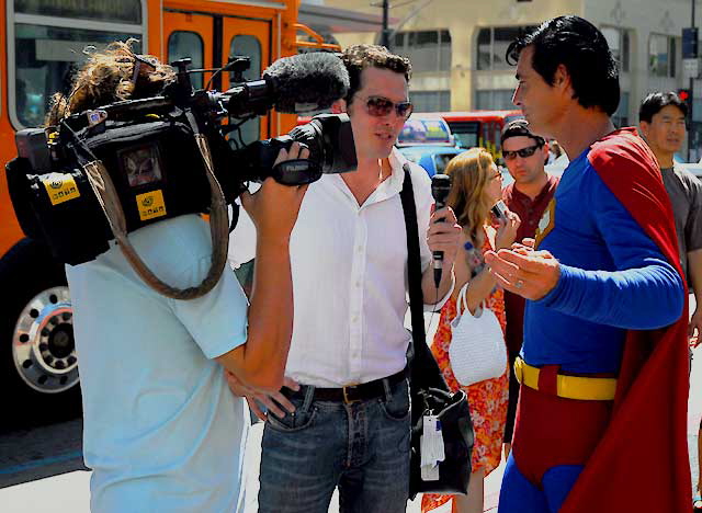 Superman impersonator being interviewed in front of Grauman's Chinese Theater, Hollywood Boulevard