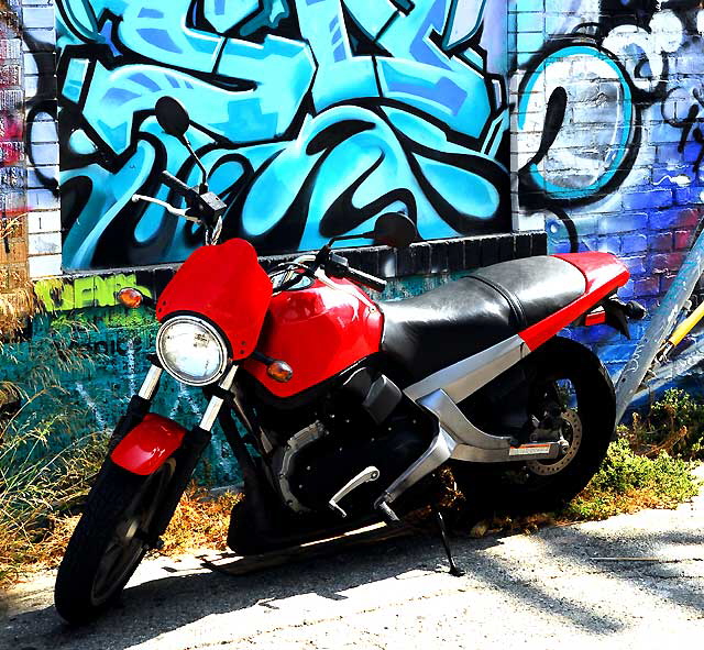 Red scooter and painted brick wall