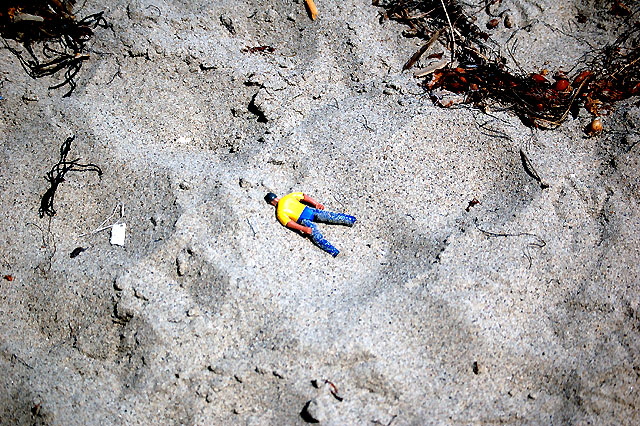 "Dead Man" toy at the foot of a low cliff in Malibu