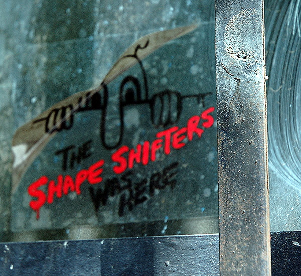 In the window of an abandoned shack just north of Hollywood and Vine - "Shape Shifters" sticker