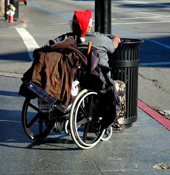 Homeless man in wheelchair wearing Santa hat, Hollywood Boulevard
