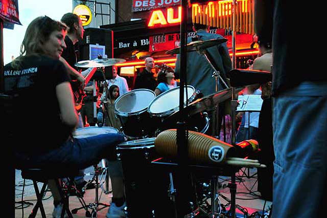 Fte de la Musique 2008 - "Red light all over from the neon, lots of folks, half were watching the football match on TV. Played a long set, started before we arrived and still going when we left. The congas guy took over the drums while the drummer had a drink."